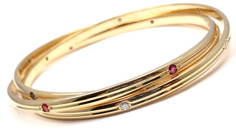 18k Yellow Gold Diamond Ruby & Sapphire Trinity Bangle Bracelet by Cartier. 
With 6 round brilliant cut diamonds VVS1 clarity, E color,
6 rubies and 6 sapphires.
This bracelet comes with original Cartier box.

Details:
Length: 7