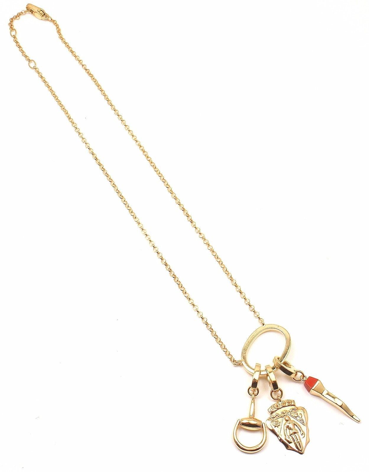18k yellow gold coral multi-charm emblem horsebit necklace from Gucci.

Measurements:
Measurements: 23mm x 50mm
Length: 16