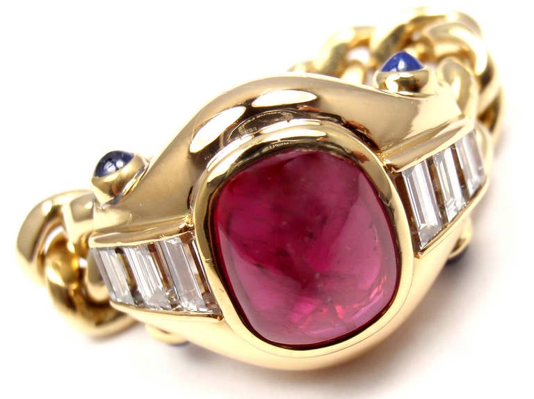 18k Yellow Gold Diamond, Ruby & Sapphire Band Ring by Bulgari.
With Oval Shape  Ruby 10mm x 7mm approx. 2.84ct
10 emerald cut diamonds VS1 clarity, G color total weight approx. .60ct
4 round cabochon sapphires
This ring comes with original
