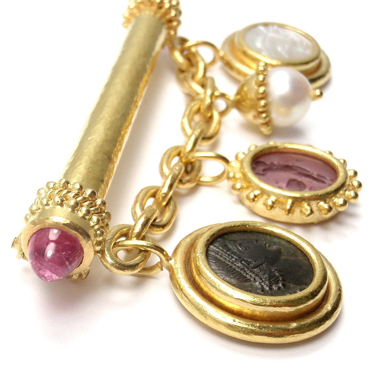 18k Yellow Gold Intaglio Tourmaline Charm Brooch Pin by Elizabeth Locke. 
With 32 TRIANGULAR SHAPED ENDS MADE OF PINK TOURMALINE 5MM EACH 
1 X PINK MOTHER OF PEARL WITH GLASS OVERLAY THAT IS 10MM
1 X PEARL, 8MM
1 X MOTHER OF PEARL WITH GLASS