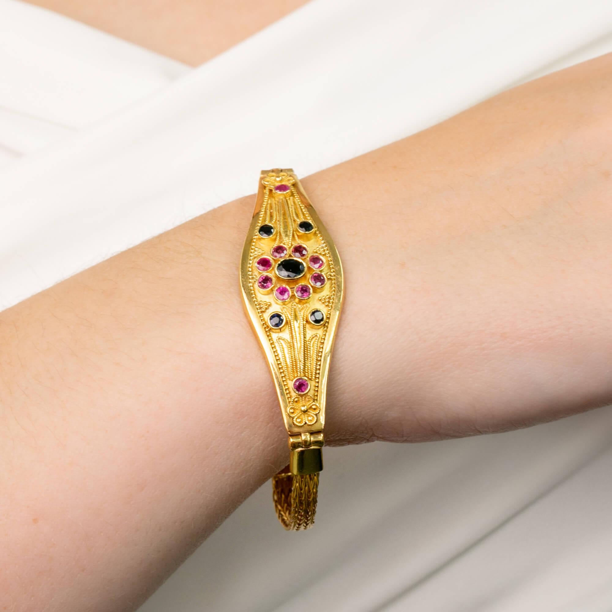 Une belle pièce ornée de la fin du 20e siècle. Ce bracelet de conception et de fabrication moyen-orientales est réalisé en or jaune 22 carats et se compose d'un panneau central bombé et effilé, orné de fines granulations et de pierres précieuses