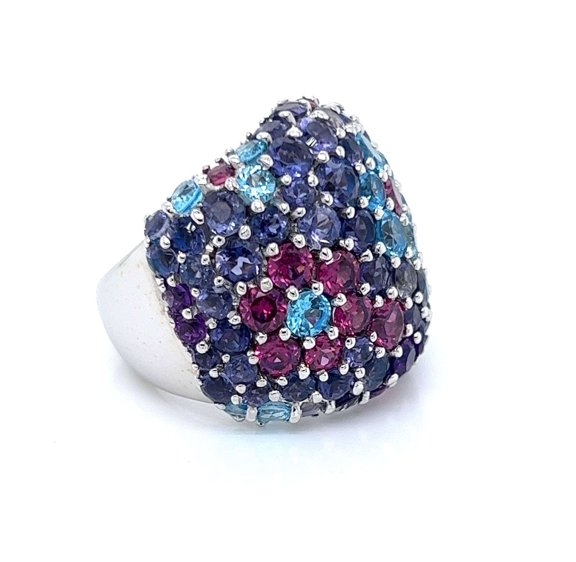 This is a stunning authentic large wide dome band ring by Pasquale Bruni, it is crafted from 18k white gold, it has iolite, blue topaz and rhodolite garnets mounted in prongs on the front of this 24mm wide dome ring. The blue topaz and garnets are