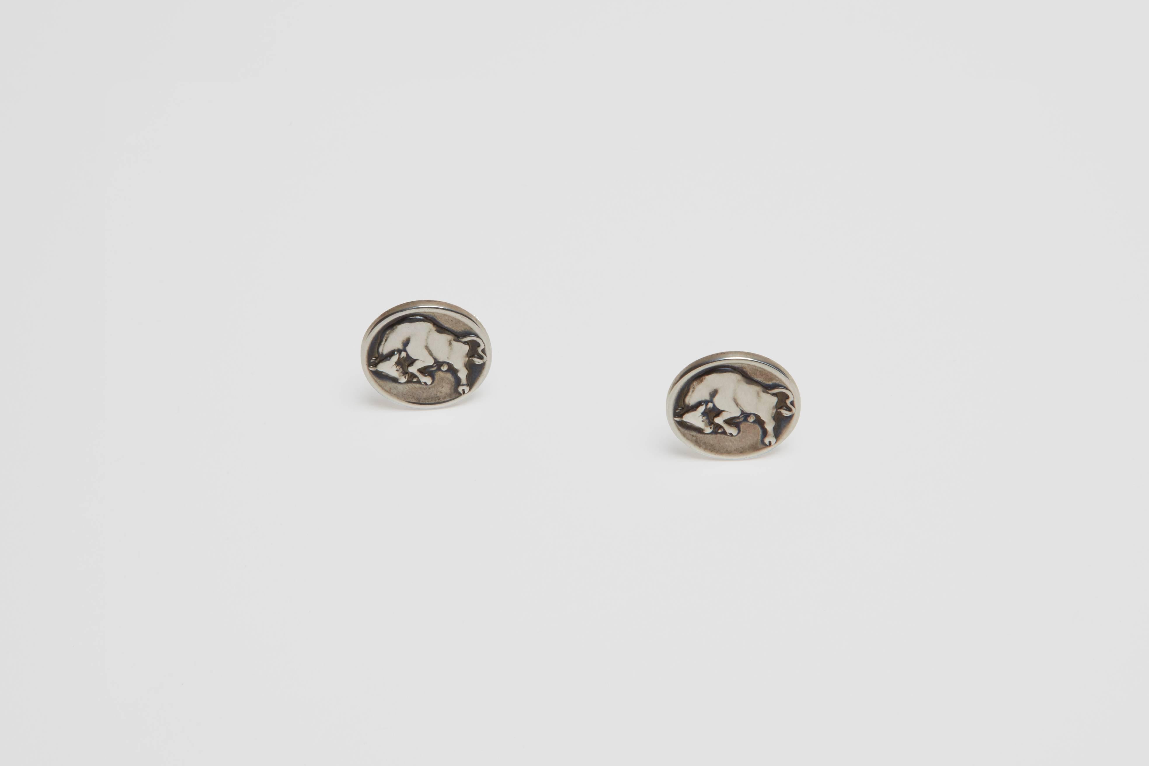 A pair of sterling silver cufflinks featuring a charging bull made in Denmark by Georg Jensen. This pair of cufflinks has the design attribution by Arno Malinowski. Malinowski was a silver designer, a sculptor, ceramist, engraver and medalist. He