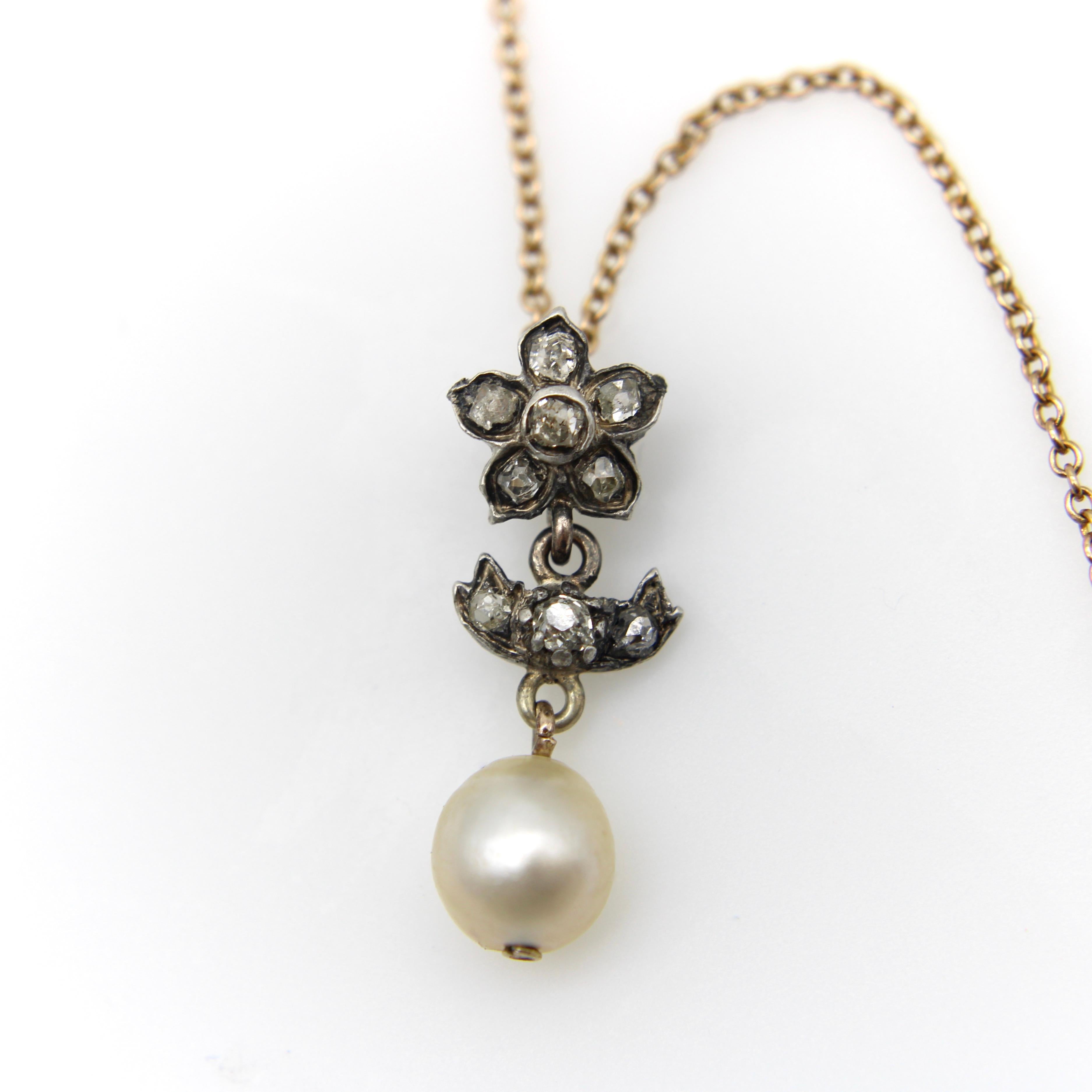 Dies ist ein früher viktorianischer Blumenanhänger aus Silber, der an einer 10-karätigen Goldkette hängt. Der Anhänger ist eine zarte Blume, die in ihren Blütenblättern Diamanten im Old Mine Cut enthält. Jeder Diamant ist eine Variation eines Old
