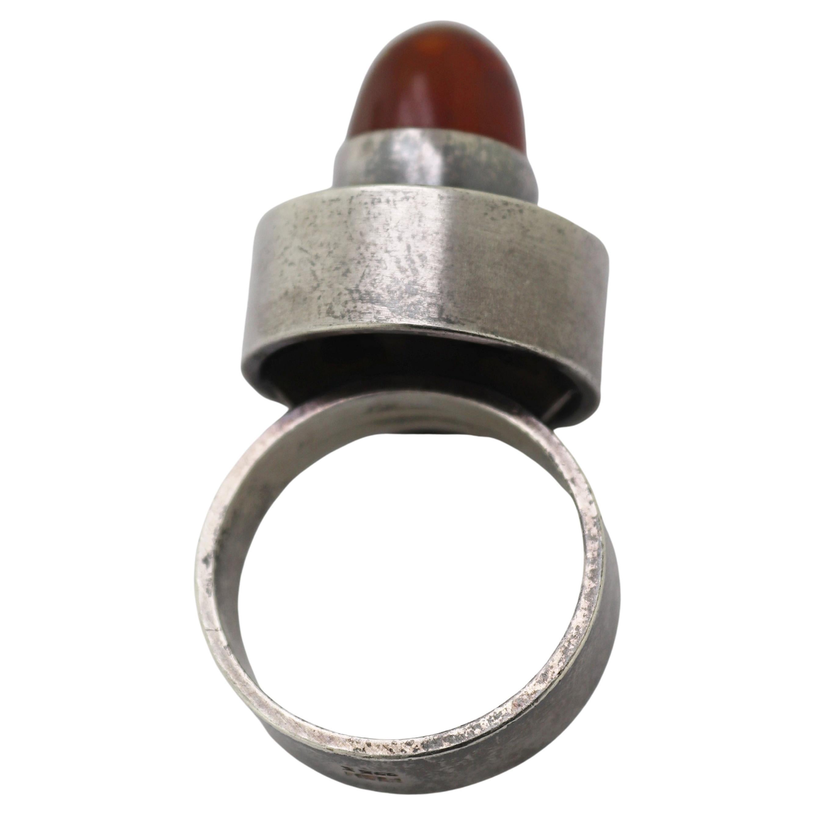 Centering one round high domed amber cabochon, 8.3 X 7.2 mm, bezel set in a sterling silver
modern geometric mounting, 16.6 X 19.1 X 7.2 mm, size: 6, marked: FROM 925S, Gross
Weight: 9.97 grams.