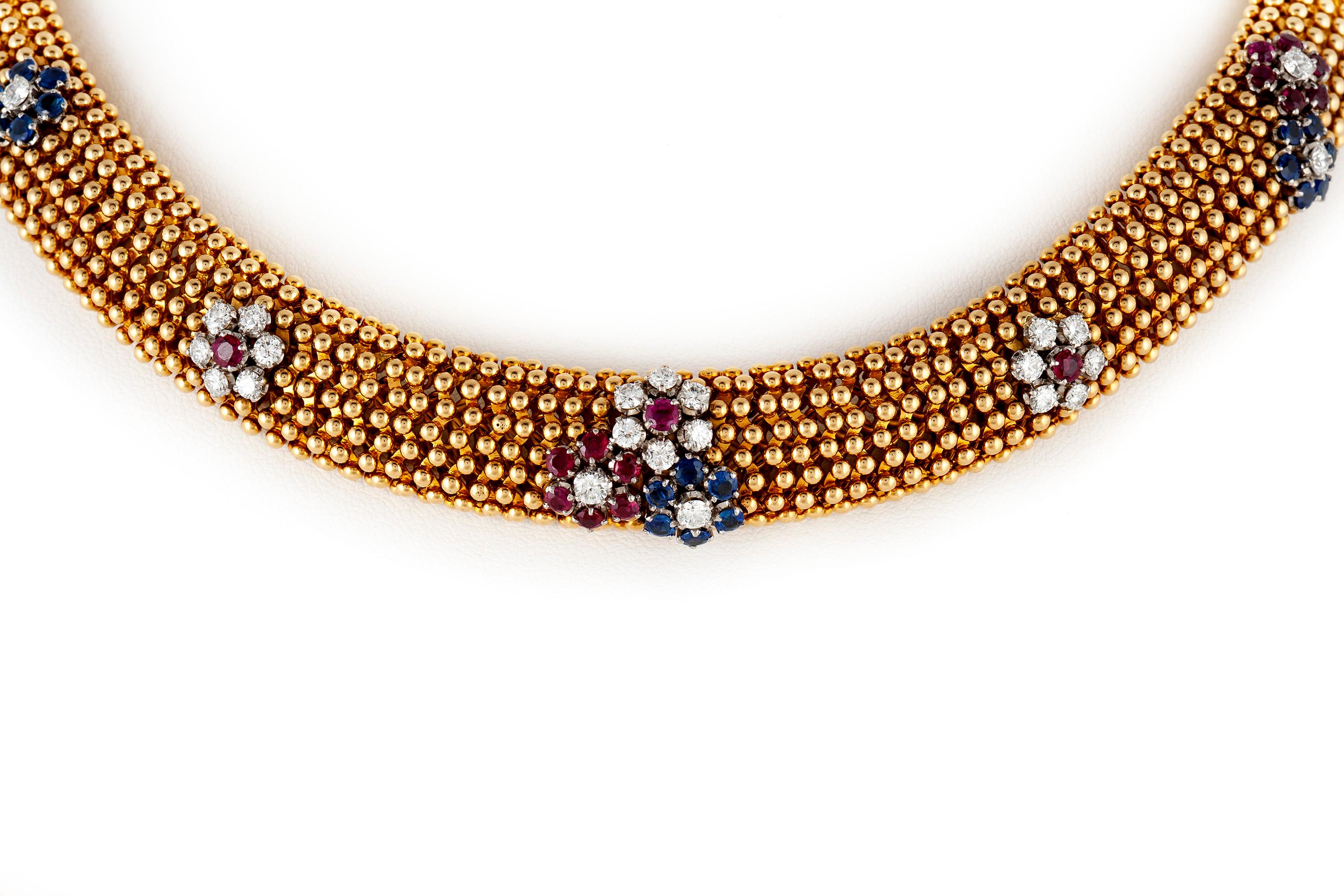 Vintage choker necklace, finely crafted in 18 k yellow gold, accented with flower motifs created with brilliant cut diamonds, sapphires and rubies. The necklace converts to two bracelets, measuring 7.5 inches and 8 inches. 