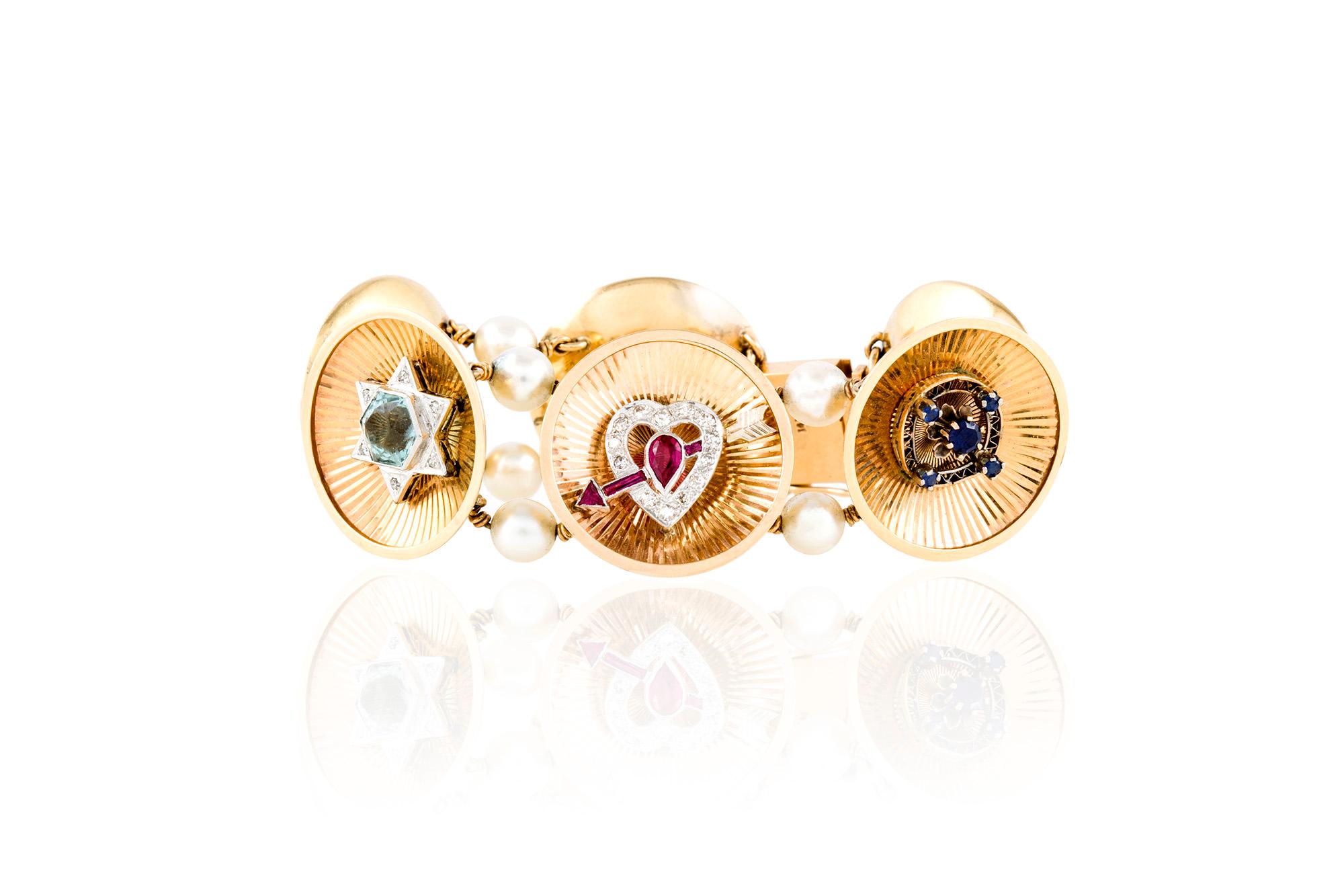 Vintage bracelet, finely crafted in 14 k yellow gold with six art deco, charms finely crafted in platinum with diamonds, sapphires and rubies. Each slide is devided with beautiful pearls. Length 7.25 inches
Circa 1940's.