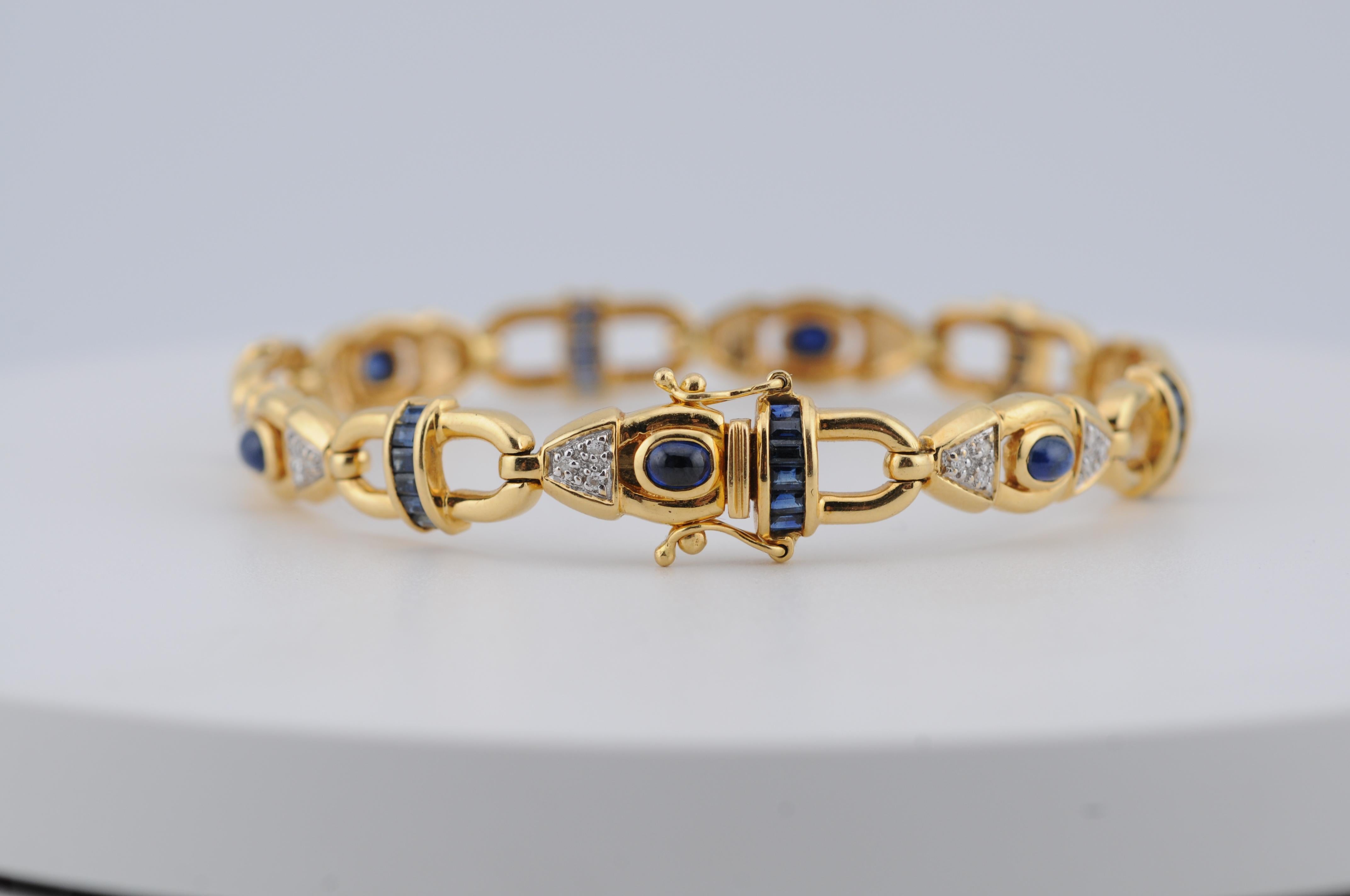 Un raffinato bracciale in oro giallo 18 carati con al centro uno zaffiro blu intenso cabochon, incorniciato da diamanti a taglio brillante. L'oggetto è caratterizzato da un'elegante lavorazione artigianale con delicati lavori in oro, che combina un