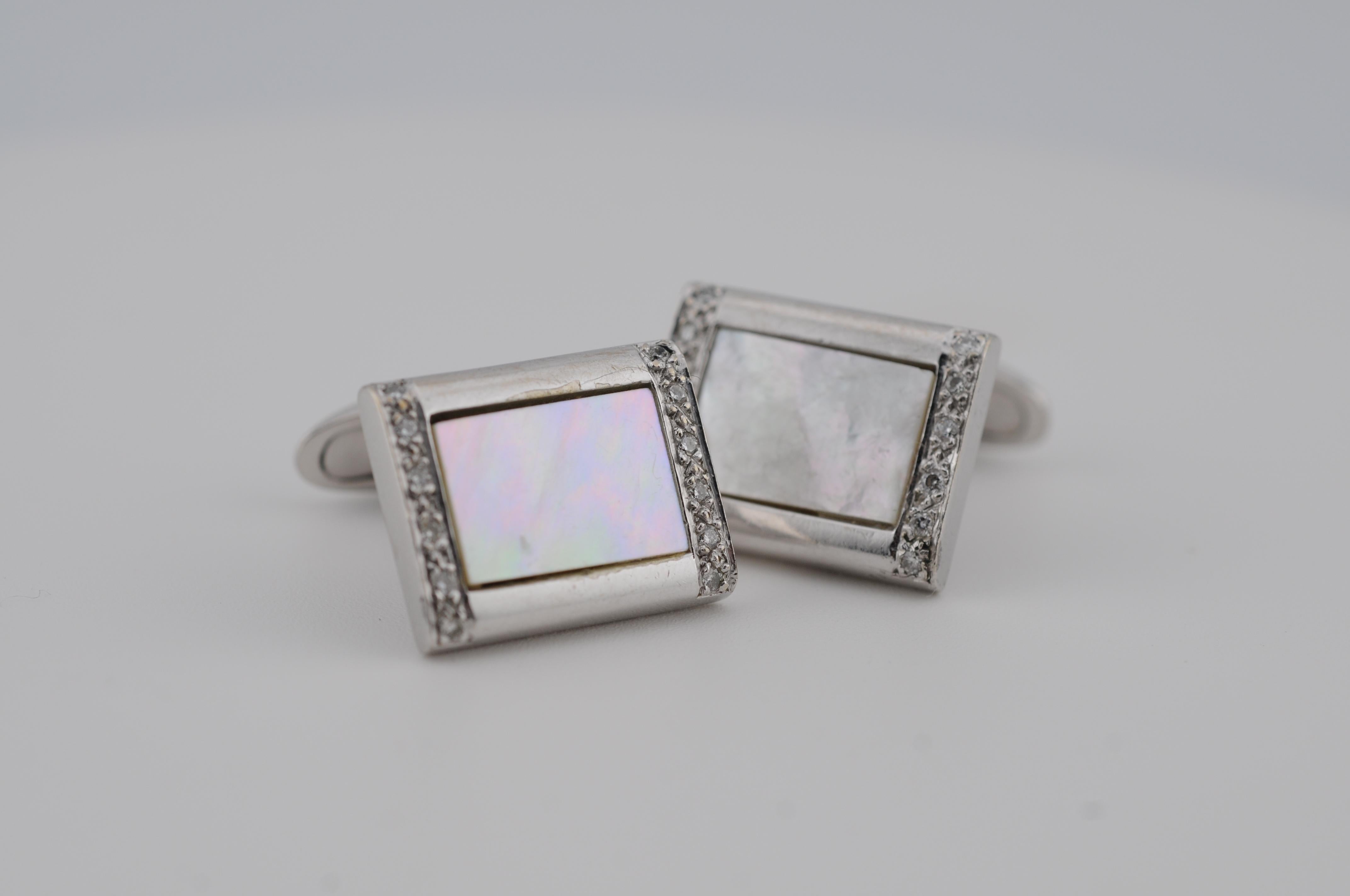 Eleganti gemelli da polso in oro bianco 14 carati, con raffinati intarsi in madreperla e piccoli diamanti taglio brillante. Un accessorio senza tempo e raffinato che aggiunge un tocco di lusso discreto a qualsiasi ensemble formale. Ideale per i