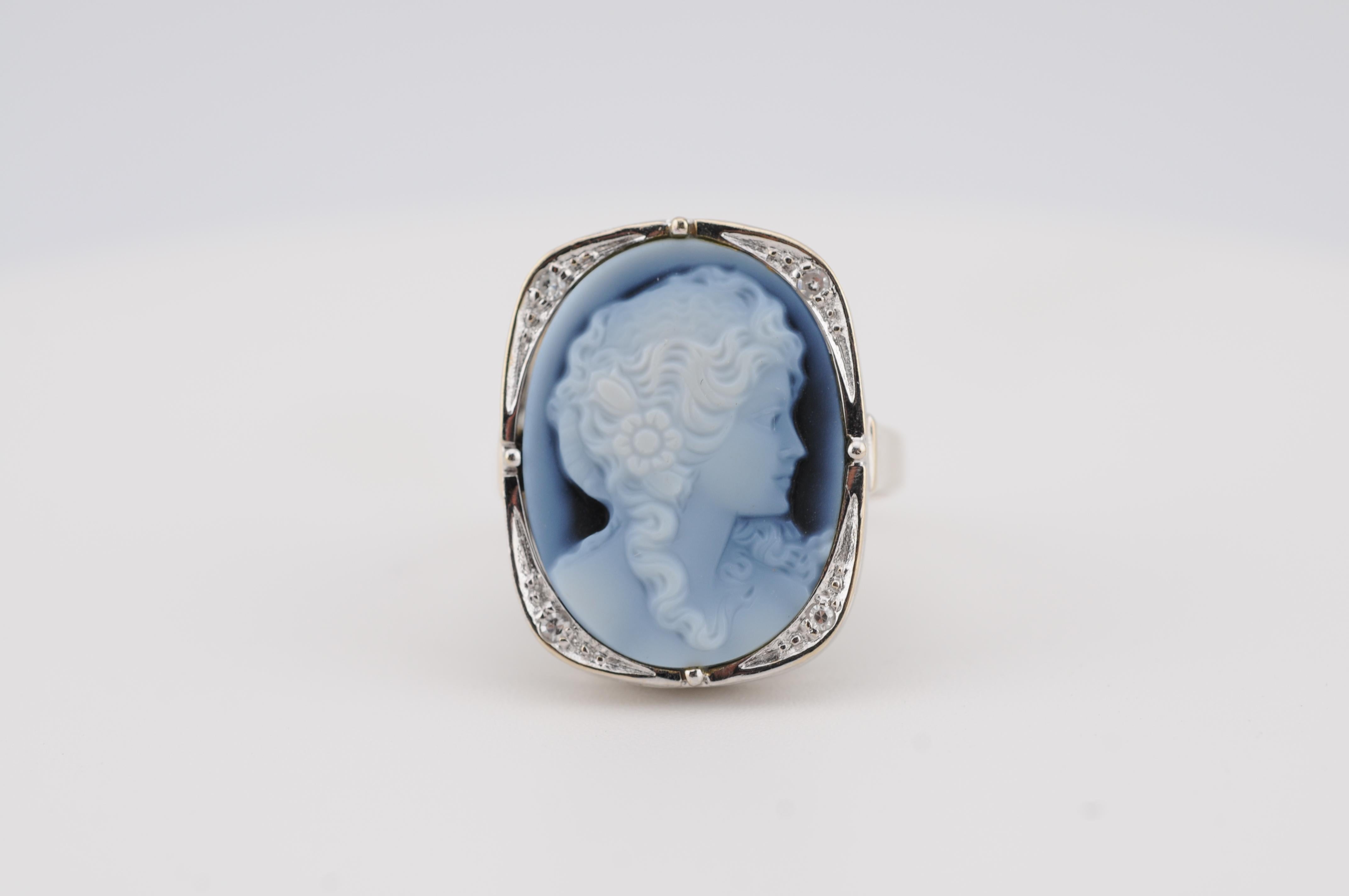 Un anello finemente lavorato con un cammeo splendidamente intagliato a mano che raffigura una giovane donna, incastonato in oro bianco 14k. Questo pezzo elegante unisce l'arte classica a un fascino senza tempo. Ideale per i collezionisti di gioielli