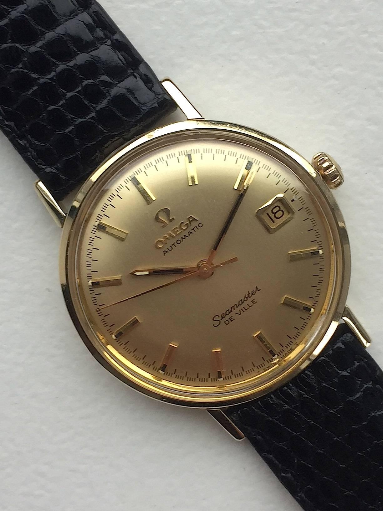 14K Yellow Gold Omega Seamaster Deville Automatic Watch 1970's
Champagne Colored Dial with Applied Hour Markers and Date at Three O'Clock
Yellow Gold Smooth Bezel
14K Yellow Gold Case
34mm in size 
Features Omega Automatic Movement with Date