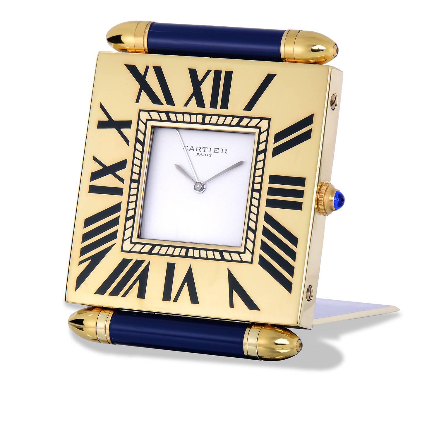 Cartier Paris Travel Alarm Clock
Quartz Movement
Made in France
Gold Plated
Lapis Enamel Decorated Top
Folding Hinged Stand with Bullet Lugs
Roman Numeral Markers
Cartier Paris Dial and Signed Case-Back
Overall Good Condition with Some Wear