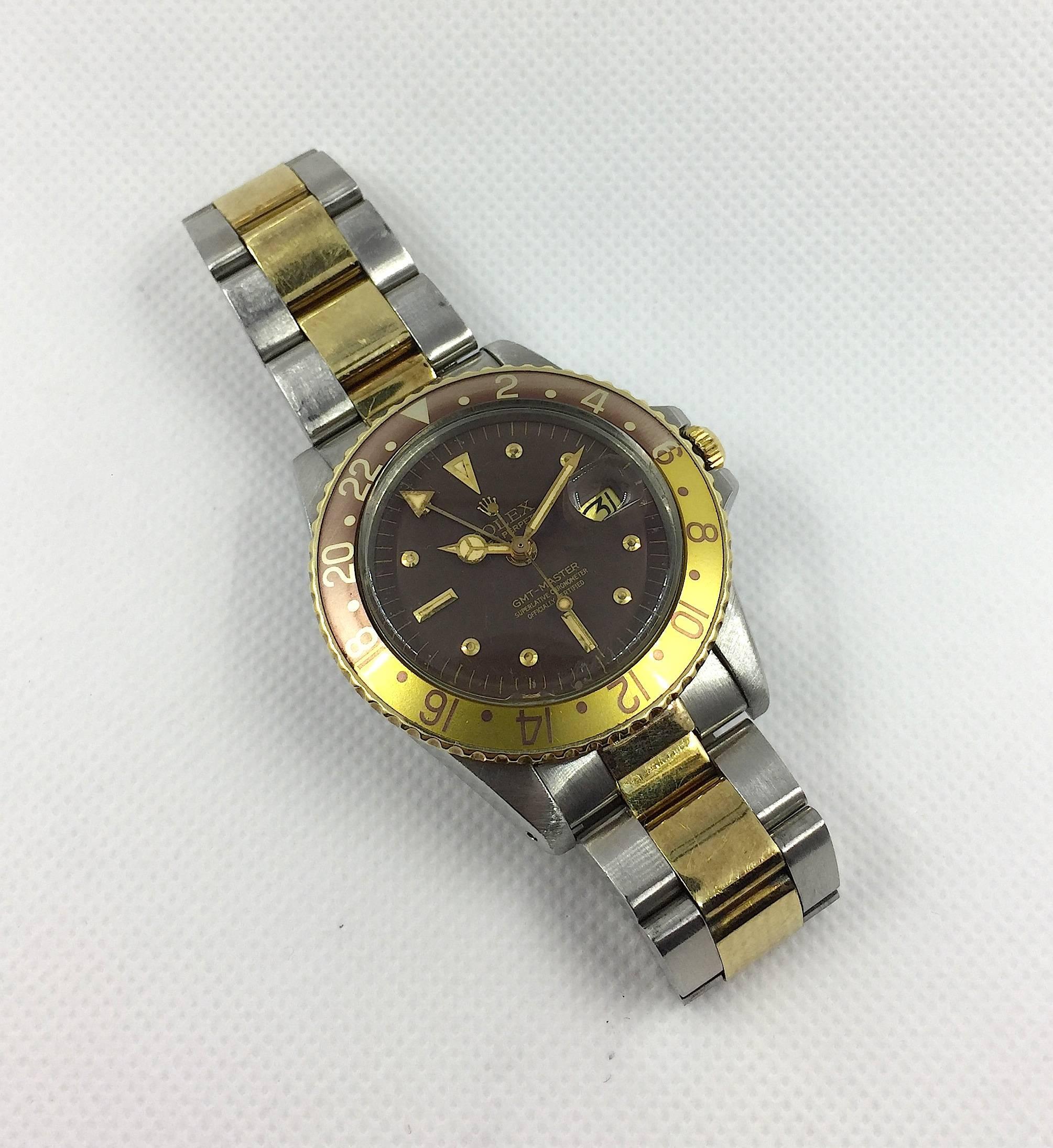 Rolex Oyster Perpetual GMT Master Wristwatch
Stainless Steel and 14K Yellow Gold
Factory Faded 'Rootbeer" Bezel insert
40mm in size 
Rolex  Calibre 1500 Base Automatic Movement
Acrylic Crystal
Quick-Set Date Function
From Mid 1970's
Watch and