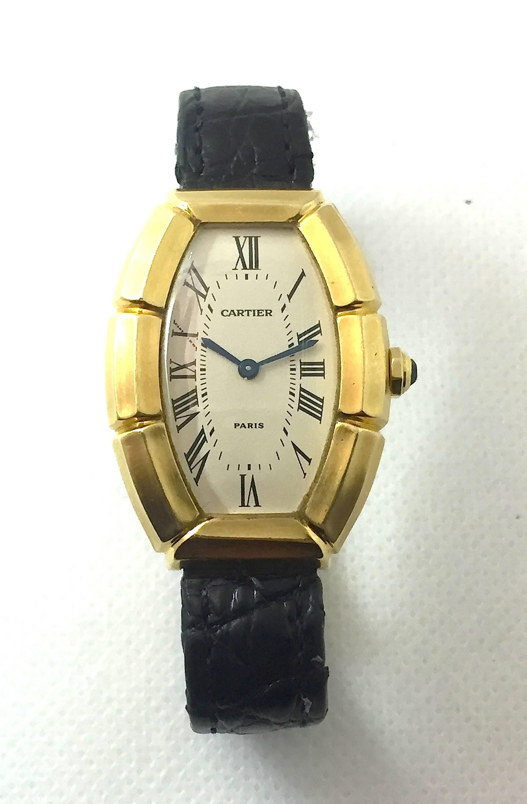 Cartier Paris Solid 18K Yellow Gold Watch 
Carved/Scalloped Tonneau Shape
Automatic Movement
Beautiful Original Cartier Paris Dial with Roman Numeral Markers
Classic Blue Cartier Hands
Signed and Engraved Case-Back
Cartier Blue Cabochon Crown
Signed
