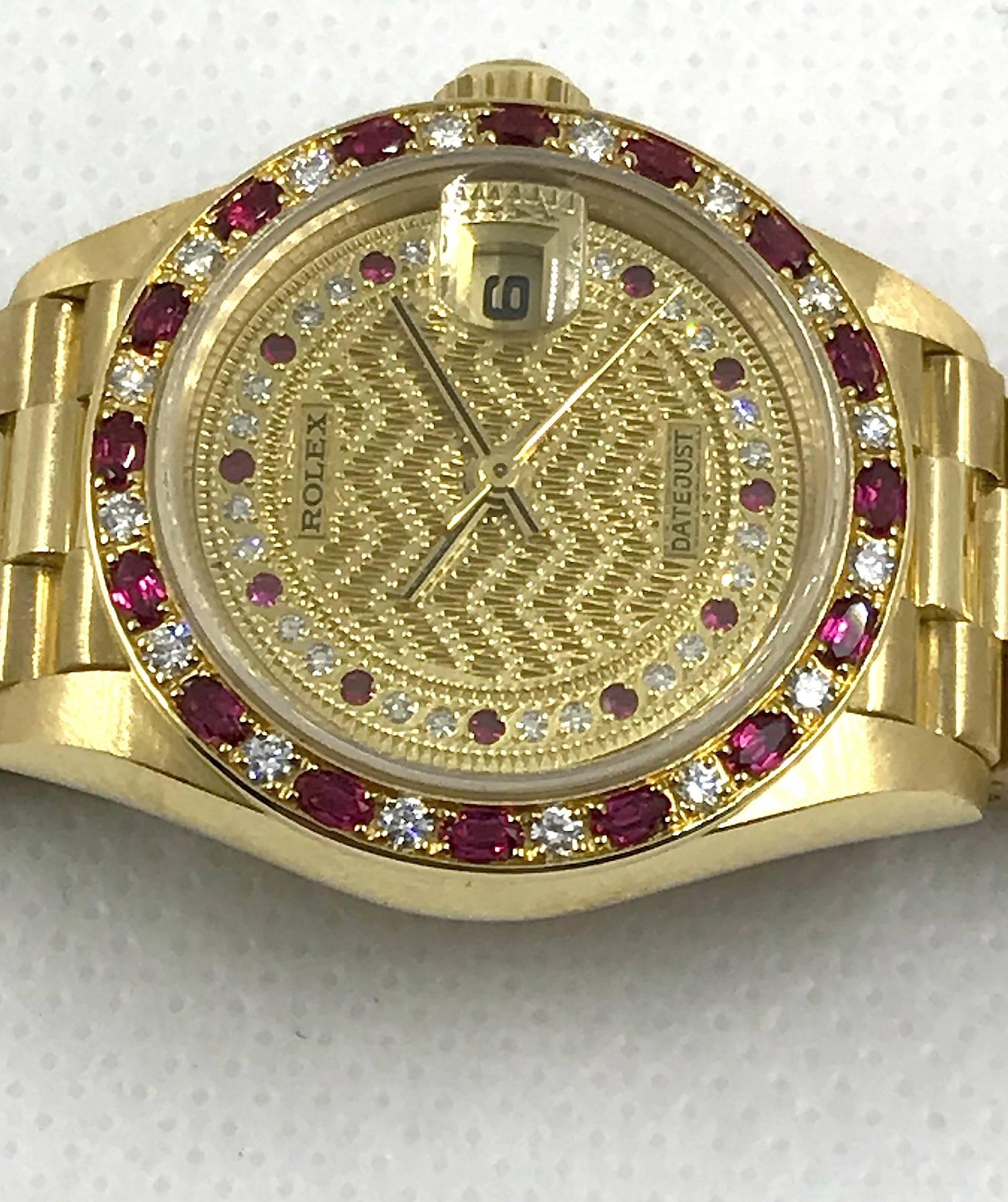 Rolex 18K Yellow Gold Oyster Perpetual Datejust Presidential Wristwatch
Factory 18K Yellow Gold Hand Carved Dial with Diamonds and Rubies
Factory Diamond and Oval Shape Ruby Bezel Set in 18K Yellow Gold
26MM in Size 
Rolex Automatic