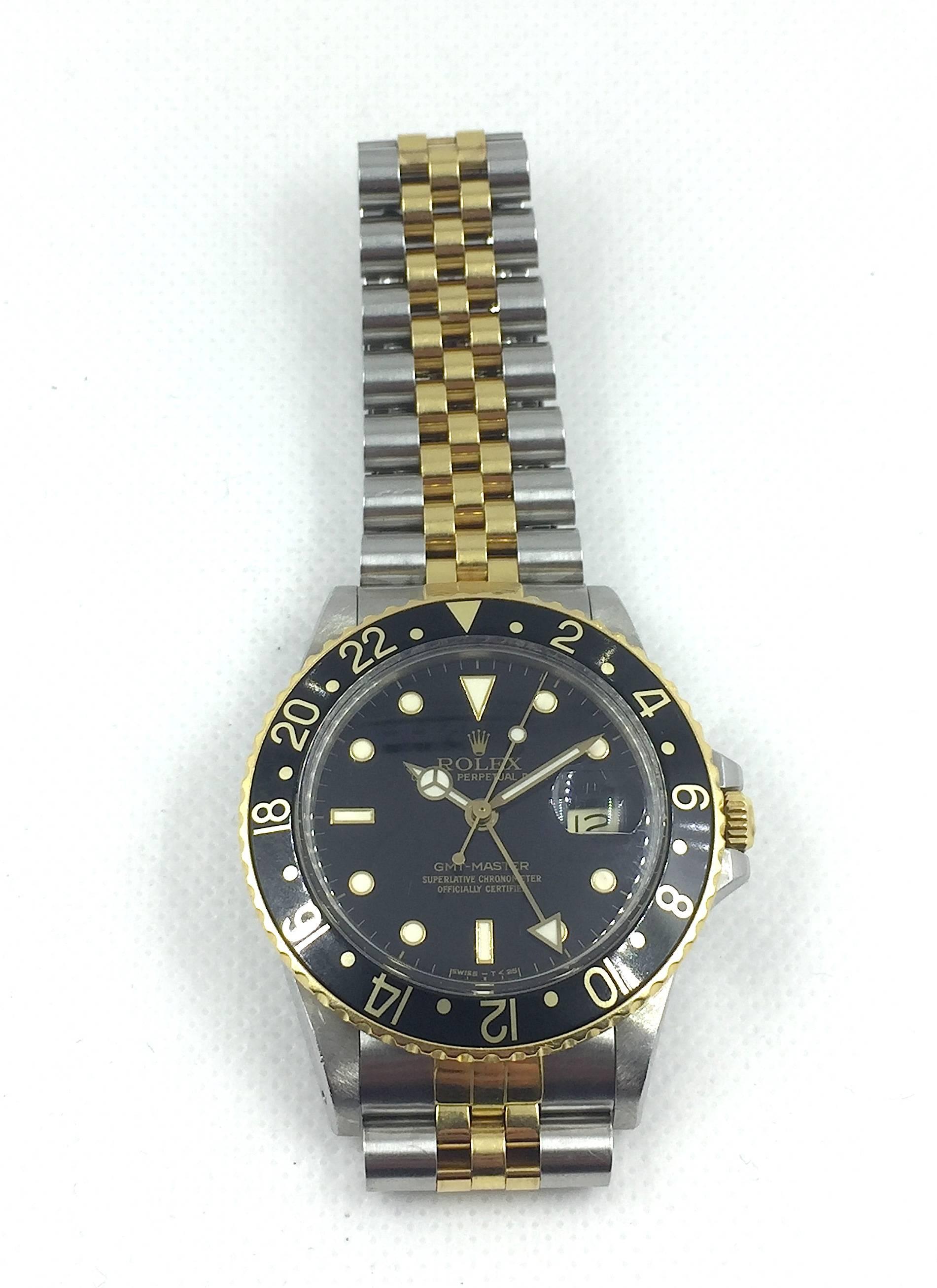 Rolex Stainless Steel and 18K Yellow Gold Oyster Perpetual GMT Master Wristwatch
Factory Black Gloss Dial with Luminous Markers 
Matching Black and Gold Bezel
40mm in Size
Rolex Calibre Base 3000 Automatic Quickset Movement
Acrylic Crystal
LAte