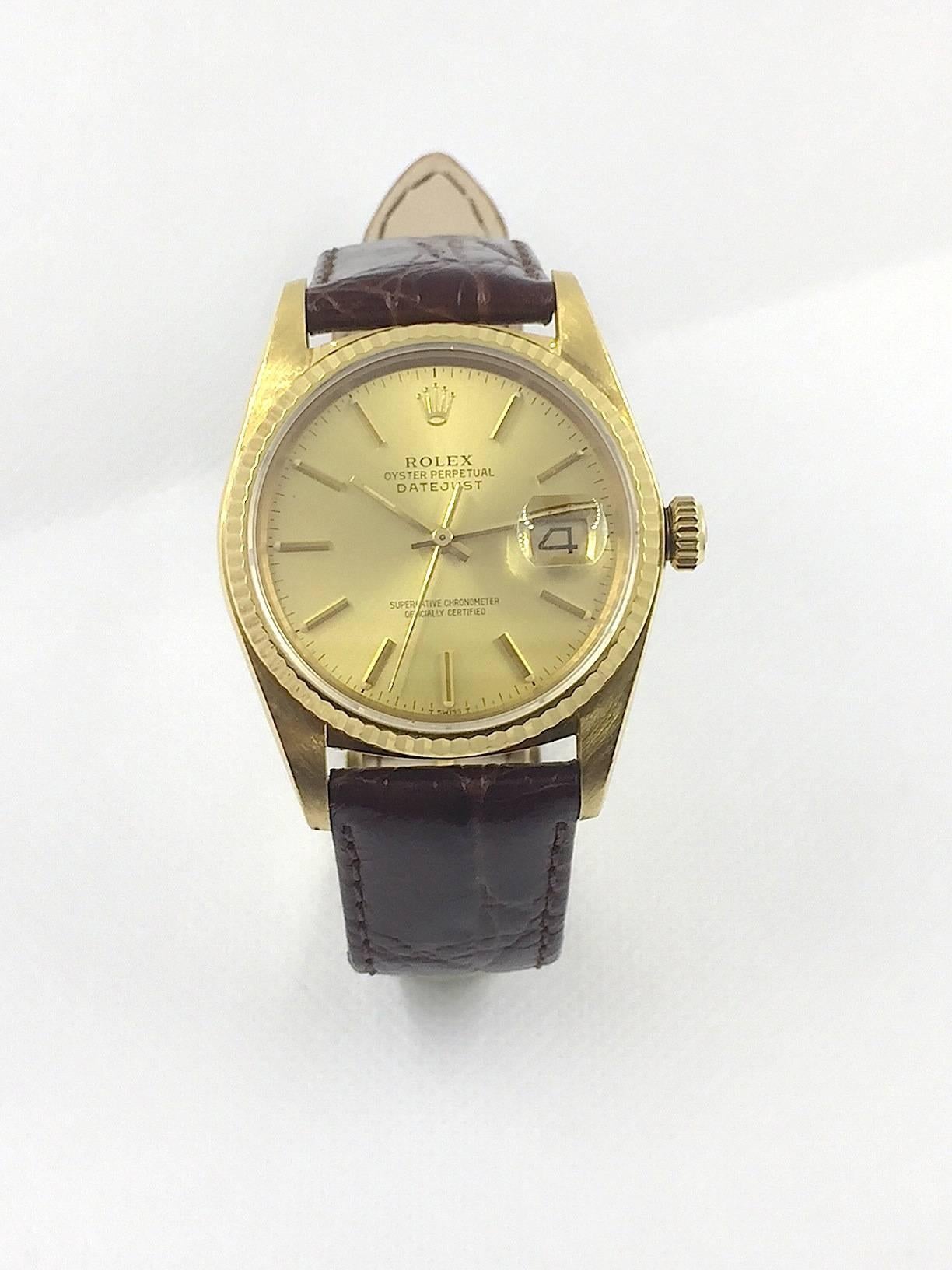Rolex 18K Yellow Gold Oyster Perpetual Datejust Wristwatch
Factory Champagne Dial with Applied Stick Numeral Markers
18K Yellow Gold Fluted Bezel
36mm in size 
Rolex Calibre Base 3035 Automatic Quick-Set Movement
Sapphire Crystal
1980's