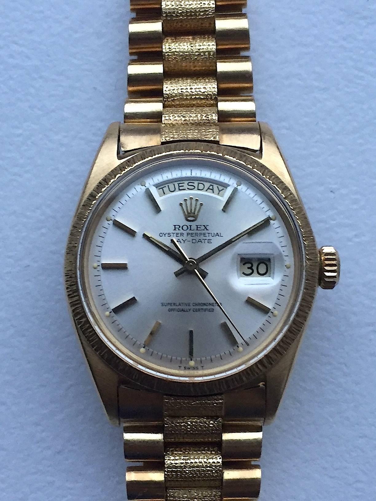Rolex 18K Yellow Gold Oyster Perpetual Day-Date Presidential Wristwatch
Factory Rolex Oyster T swiss T Dial with Applied Stick Hour Markers
Rare Reference 1807 with Factory Finish
18K Yellow Gold Bezel with Bark Finish
36MM in Size 
Rolex Calibre