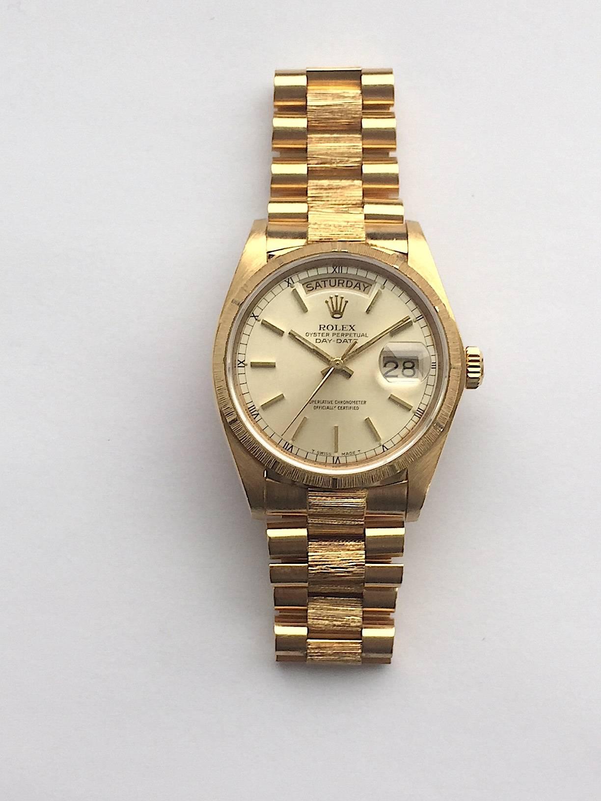 Rolex 18K Yellow Gold Oyster Perpetual Day-Date Watch with Factory Bark Finish
 Rolex Factory Champagne Dial with Applied Stick Hour Markers
Factory Bark Finish Bezel and Matching Bark Finish Bracelet
18K Yellow Gold Case
36mm in size 
Features