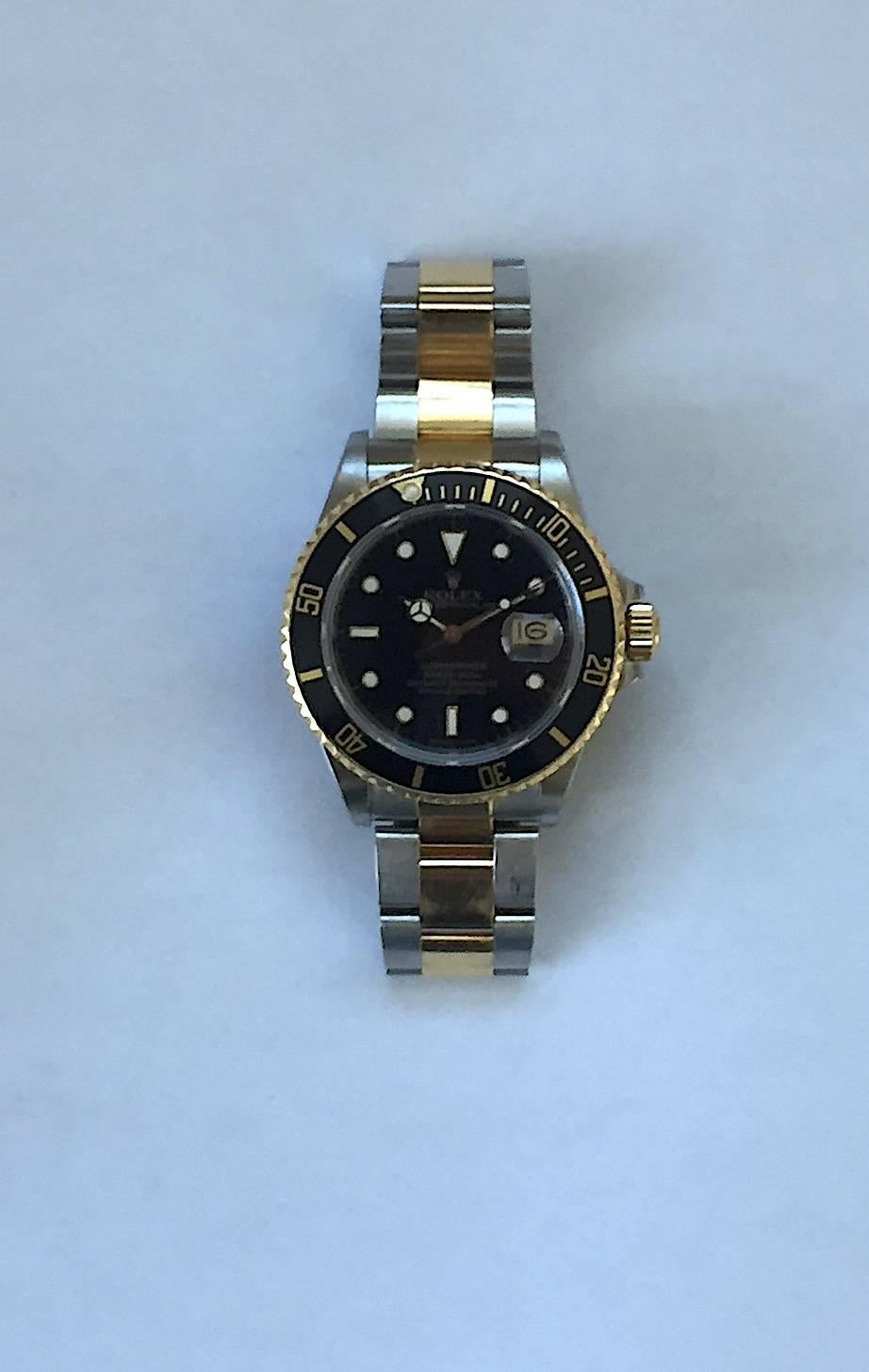 Rolex Stainless Steel and Yellow Gold Oyster Perpetual Submariner Watch
Factory Black Gloss Dial with Applied Hour Markers 
Yellow Gold Rotating Bezel with Black and Gold Insert
40mm in Size
Comes Fitted on Original Rolex Steel and Gold Oyster