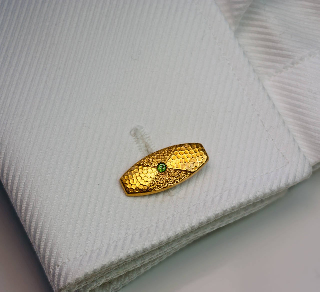 Made in Odessa between 1908 and 1917

14K gold cufflinks designed to imitate hammered and gold nugget surfaces, each centered with a Russian demantoid garnet

Marked with maker's initials and 56 zolotnik gold standard

Width 22 mm (7/8 in.)