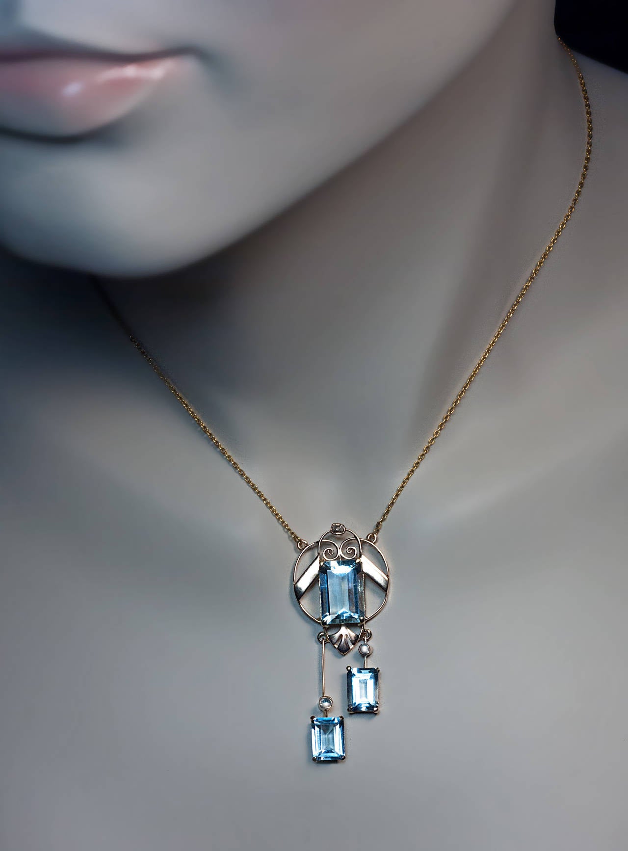 The 14K rose and yellow gold early Art Deco pendant necklace was made in Moscow between 1908 and 1917. 
The openwork negligee pendant features three emerald cut cool blue aquamarines.

Marked with 56 zolotnik gold standard and maker's