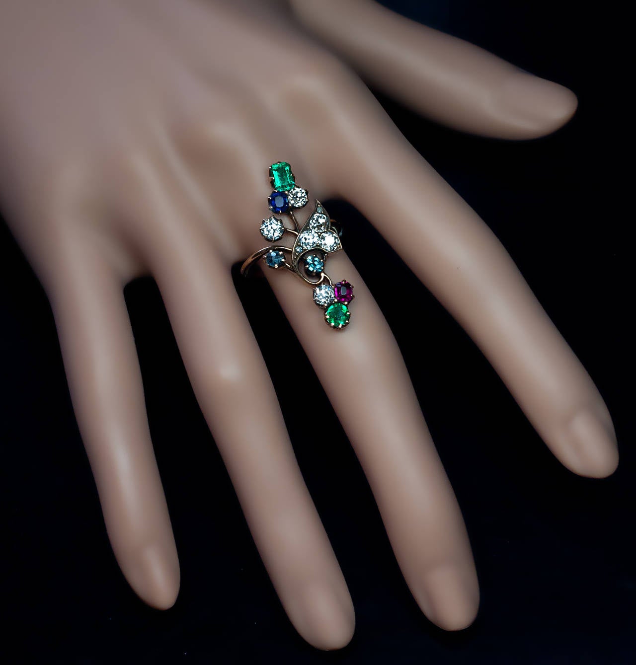 Russian, made in Kazan between 1908 and 1917

14K gold ring designed as a stylized flower set with six old cut diamonds, two emeralds, two alexandrites, one ruby and one sapphire

marked with 56 zolotnik standard and maker's initials

length
