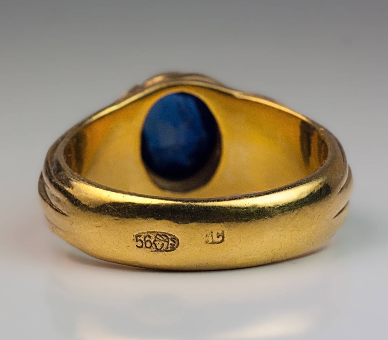 Russian, made in Moscow between 1899 and 1908

14K yellow gold ring centered with a bezel-set oval blue sapphire (7.35 x 6 x 3.5 mm, approximately 1.28 ct) flanked by Art Nouveau leaves

marked with 56 zolotnik standard and maker's