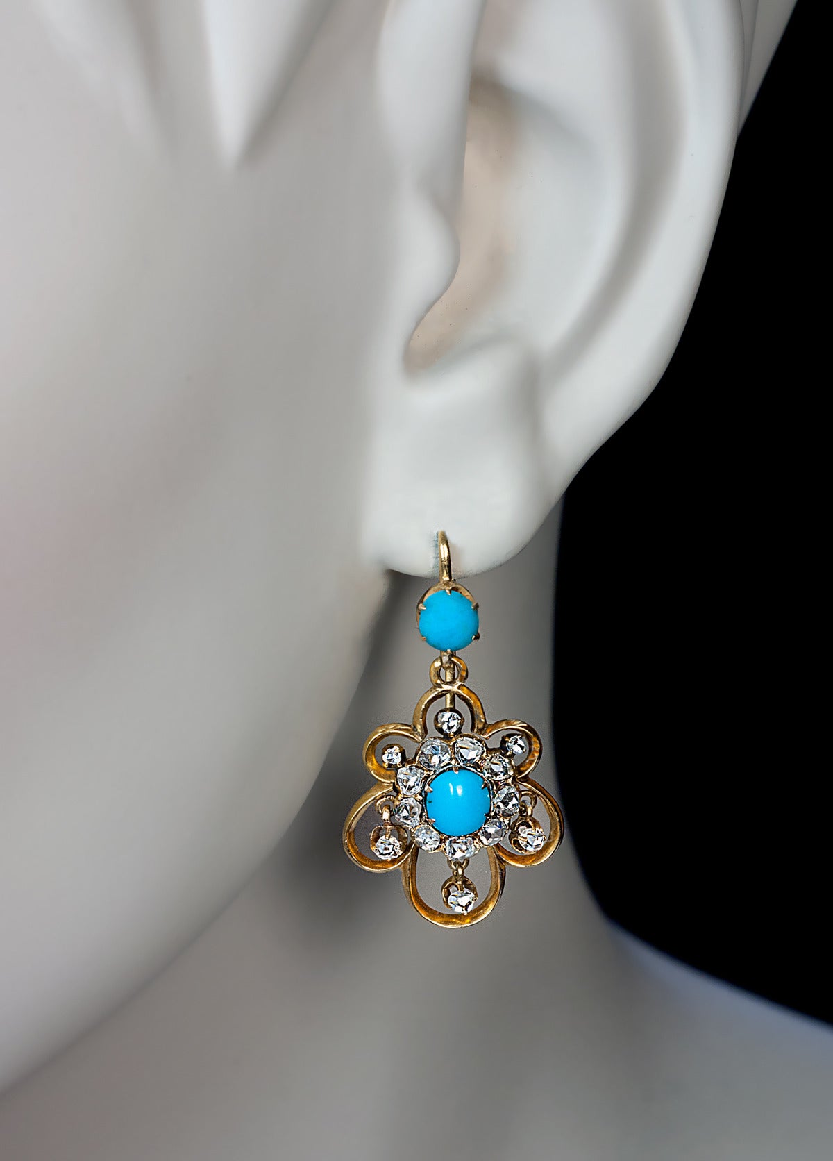 circa 1860

designed as stylized openwork gold flower heads embellished with cabochon turquoise and old rose cut diamonds

total length 34 mm (1 3/8 in.)