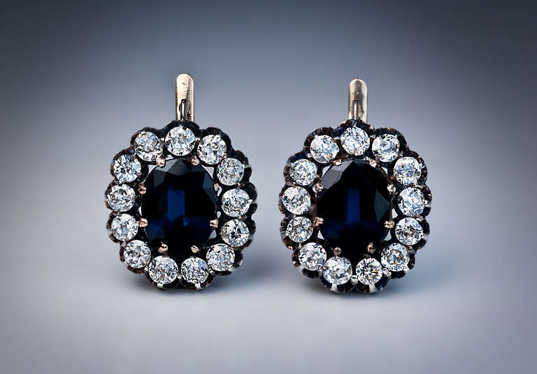 made between 1908 and 1917, marked with 56 zolotnik gold standard (14K)

The earrings are centered with prong-set oval sapphires (combined weight 6.47 ct) surrounded by old cut diamonds (estimated total weight 3.50 carats) set in silver over gold.