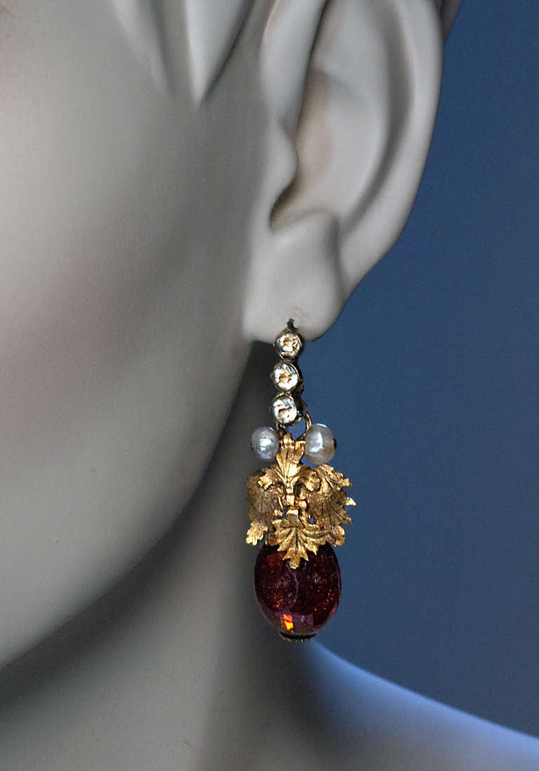 circa 1780

The earrings feature brandy brown irregular shaped polished ambers mounted with 18K gold leaves with pearl highlights.

The closures are made of gilded silver and set with foiled paste.

Completely original 18th century earrings
