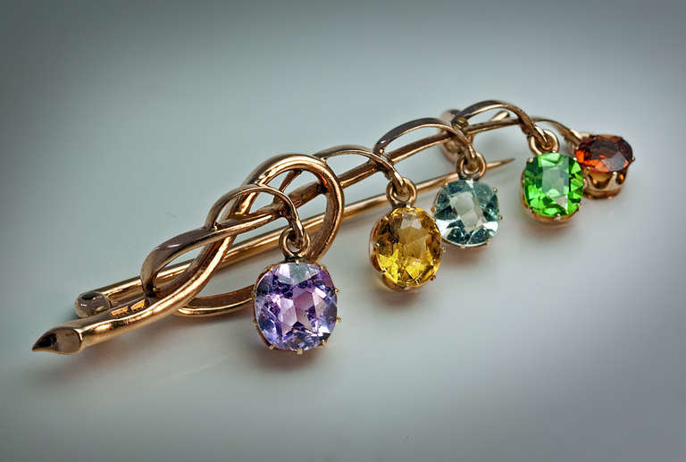 made in Moscow between 1899 and 1908

 A 14K gold brooch is formed as a stylized flower with five hanging prong-set faceted gemstones: an amethyst, a topaz, an aquamarine, a demantoid and a citrin.

 The sparkling demantoid is of an excellent