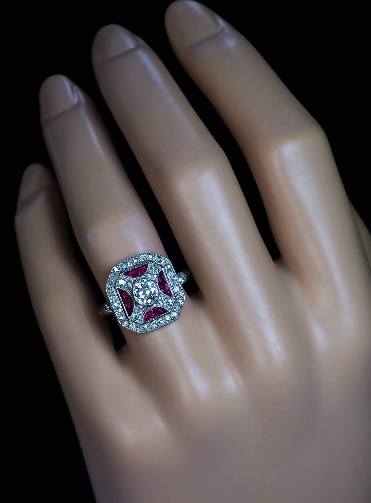 Circa 1930

Platinum over 18K gold, centered with an oval old cut diamond (5 x 4.5 x 2.9 mm, approximately 0.50 ct, H color, SI1 clarity) surrounded by calibre cut synthetic rubies and old single cut diamonds

Marked with early Soviet hallmarks