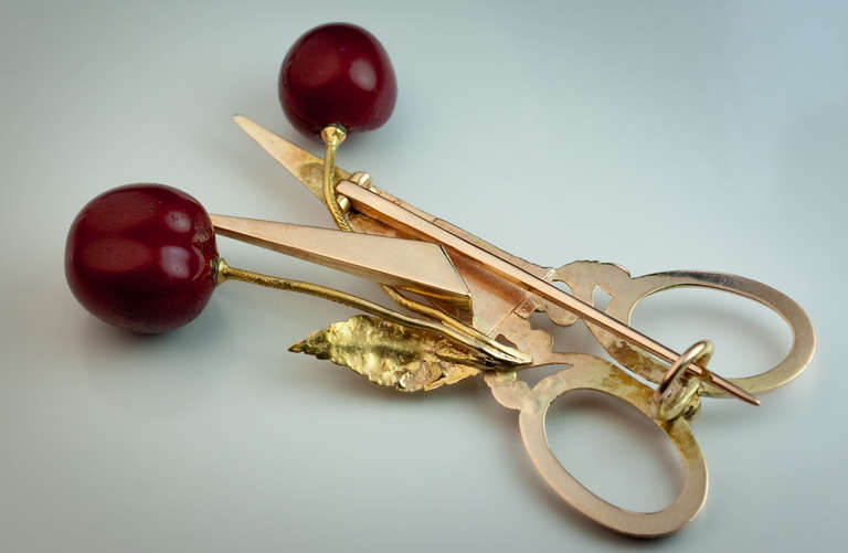 St. Petersburg 1880s.

Rose and green 14K gold, glossy enamel, designed as scissors and a pair of cherries, length 50 mm (2 in.)
