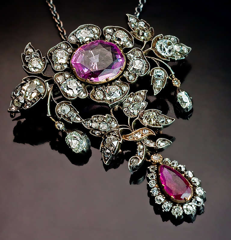 Mit floralem Design, aus Silber und 14K Gold gefertigt 

Ein ovaler rosa Saphir (9,2 x 7,8 x 2,65 mm, ca. 1,52 ct), ein birnenförmiger Rubin (7,8 x 4,2 x 1,6 mm, ca. 0,40 ct), alte Diamanten im Kissenschliff und alte Diamanten im Rosenschliff