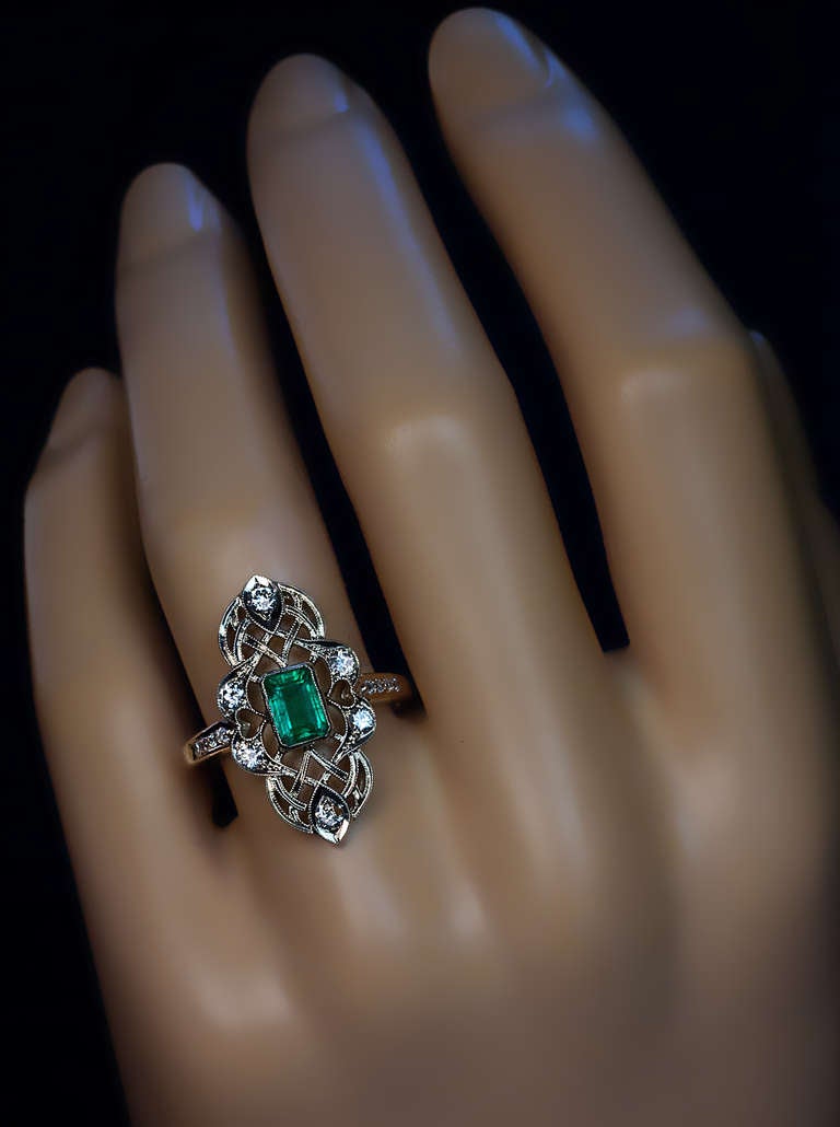 A 14K white gold openwork milgrain ring is set with a 0.78 ct emerald cut emerald,  six brilliant diamonds and eight single cut diamonds (estimated total diamond weight 0.38 ct).

 Height 25 mm (1 in.)

 US ring size 8 1/4  (18 mm)