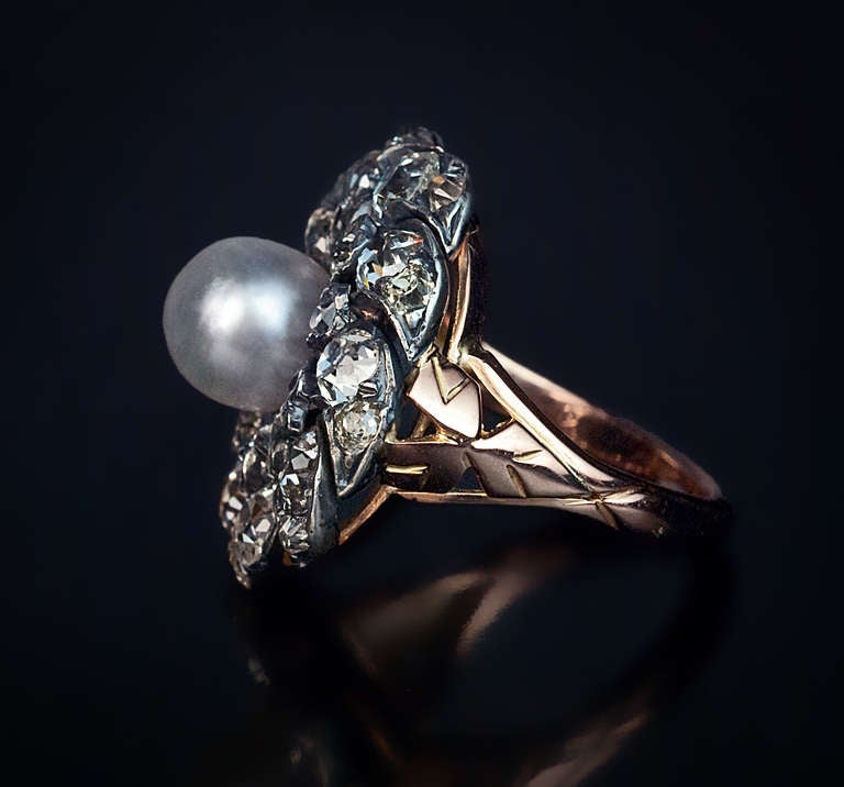 Antique Pearl and Diamond Swirling-Pattern Ring

 Circa 1880

The silver topped 18K rose gold ring is centered with an 8 mm pearl surrounded by 30 old mine / old cushion cut diamonds.

 Estimated total diamond weight 4.40 carats. 

 Diameter