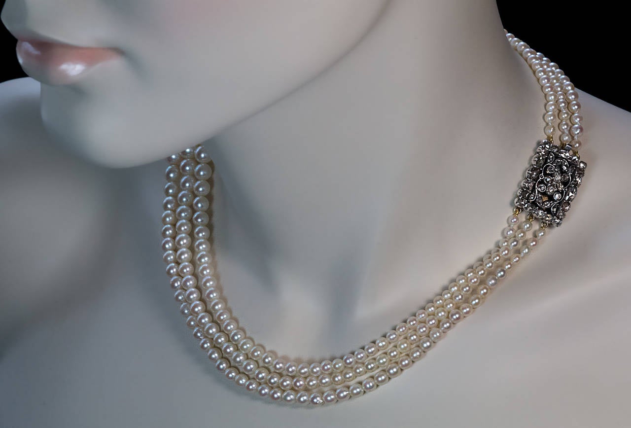 This triple strand pearl necklace was made around 1910 with a much older diamond clasp.

The silver topped gold and old rose cut diamond (over 2 cttw) openwork clasp is from the early to mid 1800s.

The necklace is marked on the back of the