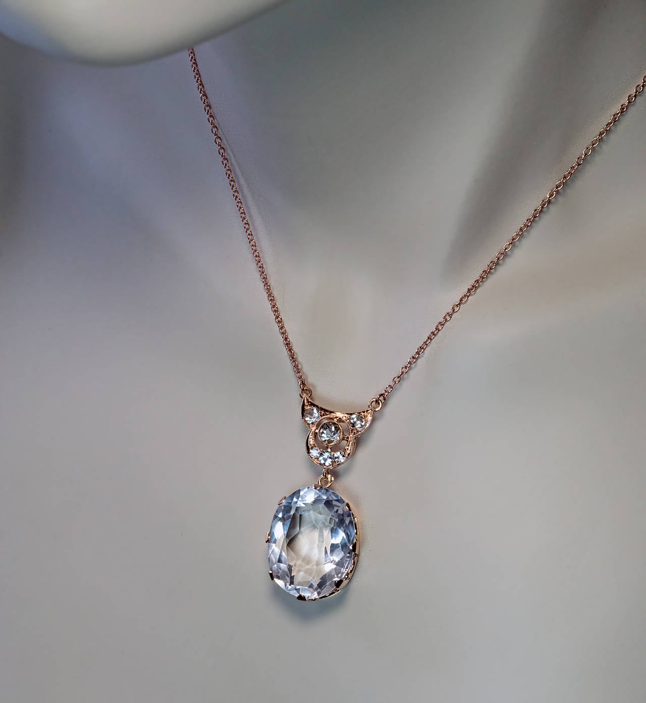 Russian, Moscow, circa 1930

The 14K rose gold necklace features a large (22.5 x 17.8 x 20.5 mm, approximately 43.51 ct) bluish white oval faceted rock crystal accented by six round ice blue spinels.

Marked with maker's initials 'P.C' and early