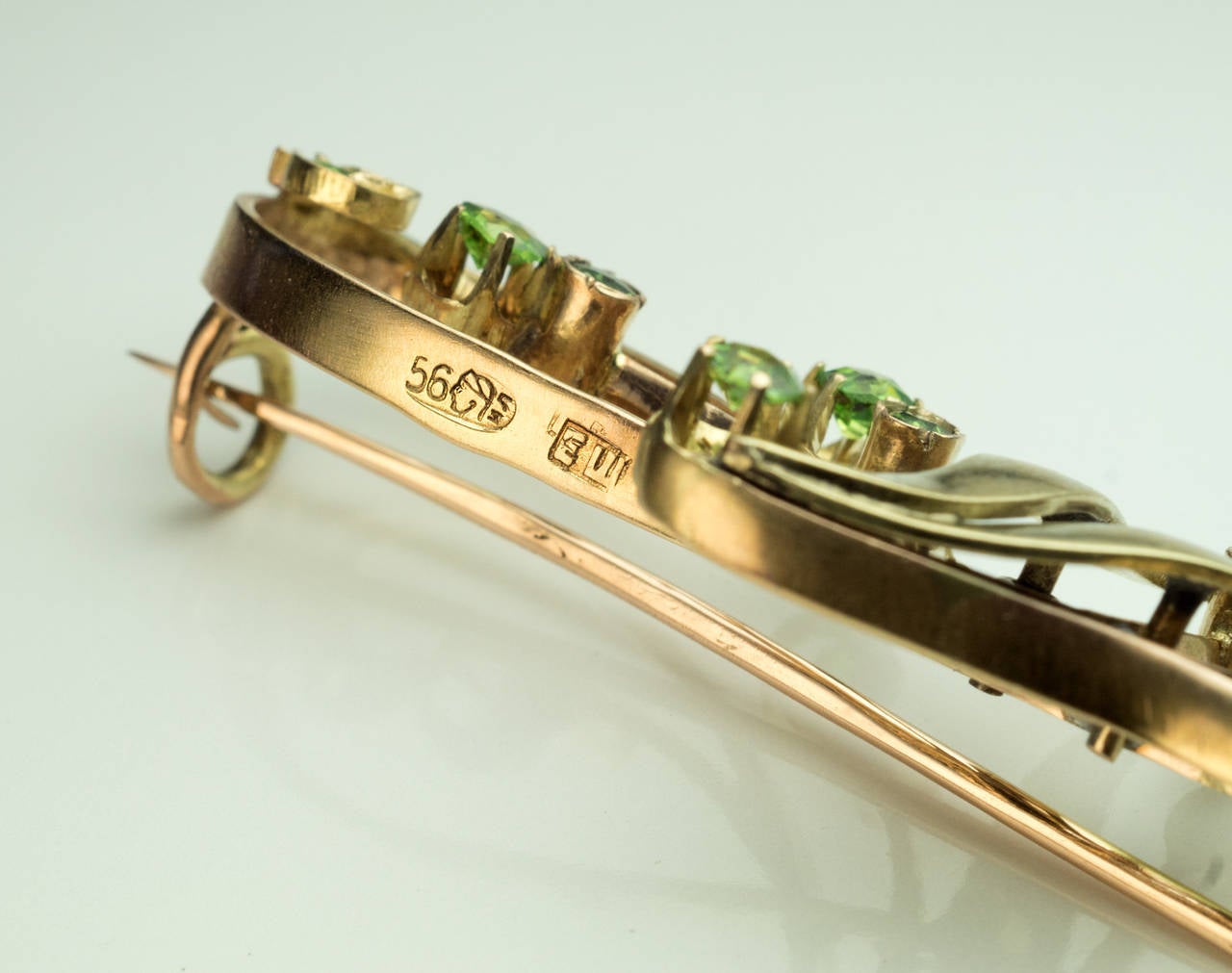 Made in Moscow between 1899 and 1908

Designed as a stylized flower in Art Nouveau taste, 14k rose and green gold, 12 sparkling green Uralian demantoids

Marked with 56 zolotnik gold standard and maker's initials

Width 47 mm (1 7/8 in.)