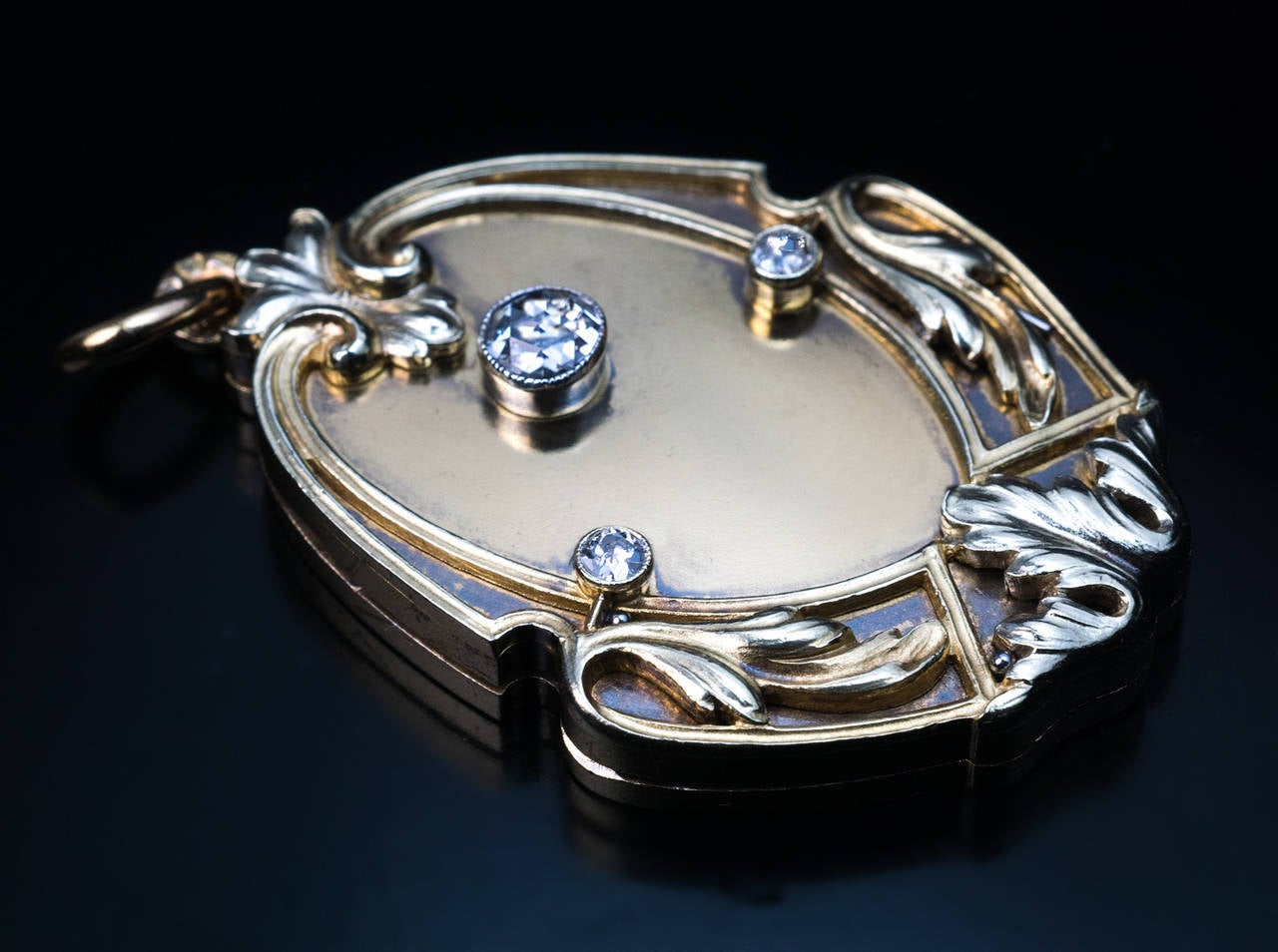 Hergestellt in Moskau zwischen 1908 und 1917

Der Medaillon-Anhänger aus mattiertem 14-karätigem Gold zeigt einen Diamanten im Rosenschliff in einem ziselierten Jugendstil-Blattrahmen, der mit zwei Diamanten im alten europäischen Schliff
