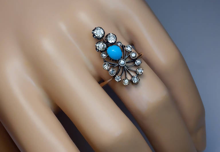 A fan shaped silver topped gold ring set with old cut diamonds and a cabochon cut turquoise

Height 26 mm (1 in.)

US ring size 7 1/2  (18 mm)