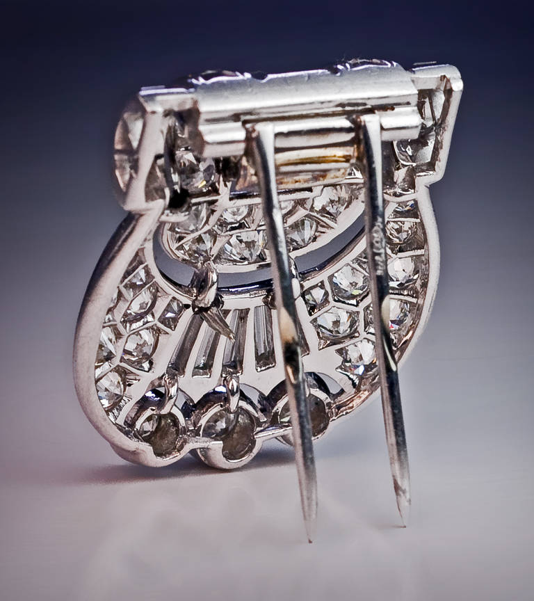 circa 1930

a handcrafted shield buckle-shaped platinum plaque with a white 18K gold clip / pin  back densely set with sparkling round and baguette cut diamonds

estimated total diamond weight about 3 carats

26 x 21 mm  (1 x 7/8 in.)