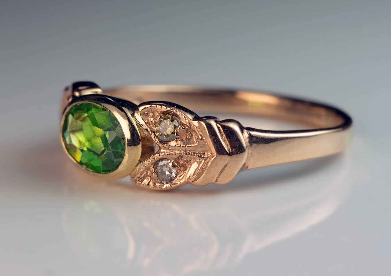 A Vintage Demantoid Engagement Ring

The 14K rose gold ring is centered with a bezel-set Russian demantoid flanked by two pairs of stylized leaves embellished with small fancy brown diamonds. The demantoid measures 6 x 4.7 x 1.85 mm, approximately