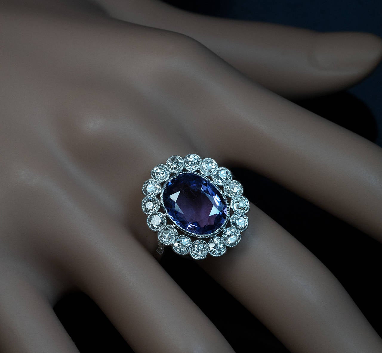 The milgran platinum ring features a 5.41 ct natural sapphire with an unusually bluish-purple color.

The sapphire is framed by 16 sparkling old European cut diamonds (I-J color, VS2-SI2 clarity).

The shoulders of the ring are set with six old