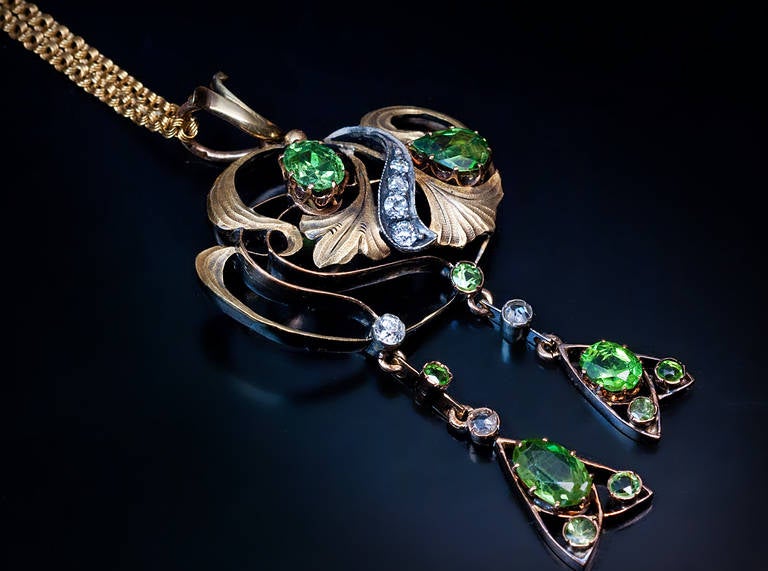 Made in Kazan between 1908 and 1917

An openwork pendant of a floral design set with Russian demantoids and diamonds

14K greenish yellow gold and silver (pendant), 14K yellow gold chain

Estimated weight of the four largest demantoids:  0.84