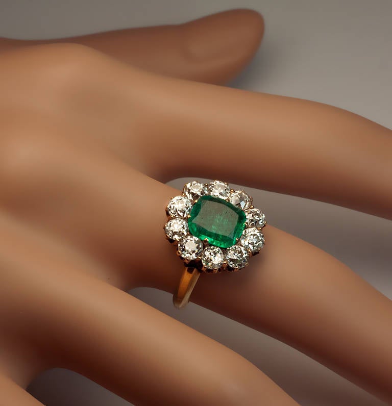 Moscow, 1880s

The ring is prong-set with a cushion cut emerald (7.9 x 7.4 x 2.8 mm, approximately 1 carat), framed by ten old European and old cushion cut diamonds, (average 3.5 x 2.5 mm,  G-H color, VS1 - SI1 clarity).
Estimated total diamond
