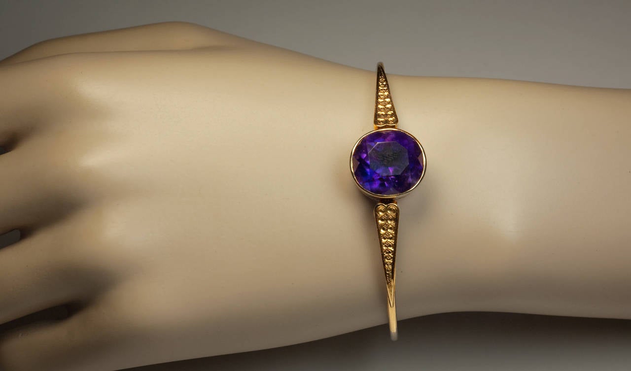 made in Moscow in 1886 or 1887

a stylish Victorian era 14K gold bracelet centered with a bezel-set  faceted Siberian amethyst ( 15 x 14 x 10 mm, approximately 12.30 ct ) flanked by hand engraved shoulders 

The bracelet is marked with 56