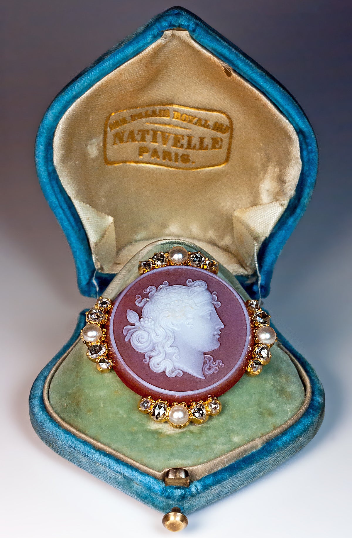 A finely carved carnelian cameo of Dionysus, the Greco-Roman god of wine making and fertility set in 18K gold bezel embellished with half pearls and rose cut diamonds

Width 37 mm (almost 1 1/2 in.)

Marked with French eagle-shaped assay