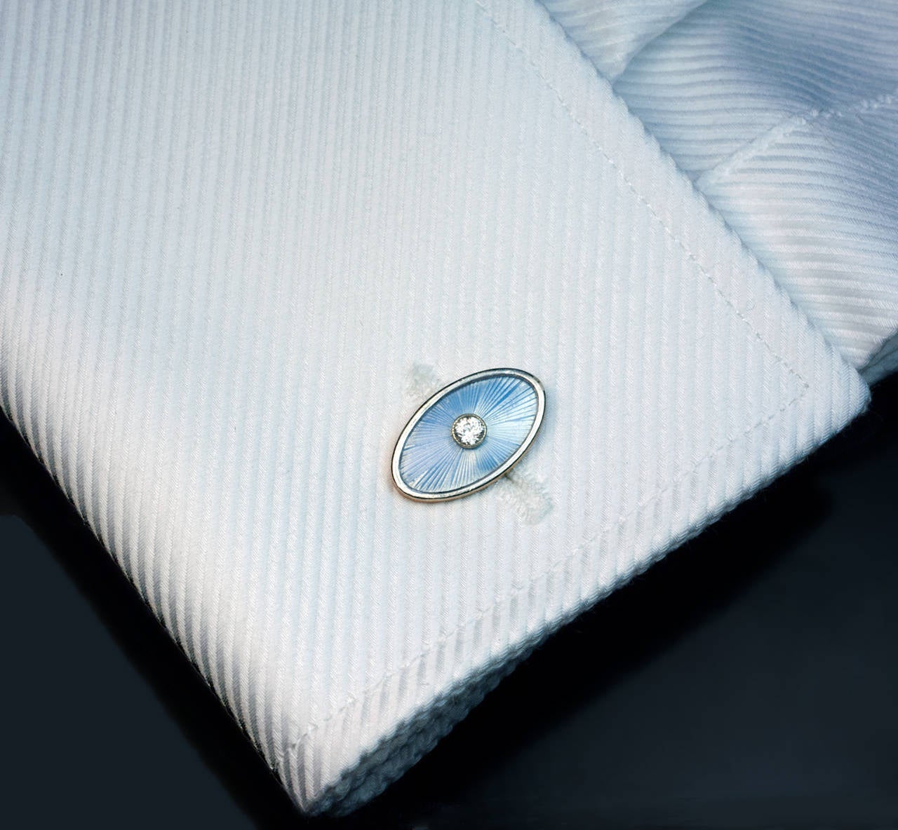 Made in St. Petersburg between 1908 and 1917

A pair of navette shaped gold cufflinks is covered with pale blue translucent enamel over a sunray guilloche pattern within platinum borders. 

Each cufflink is centered with a bezel-set old European